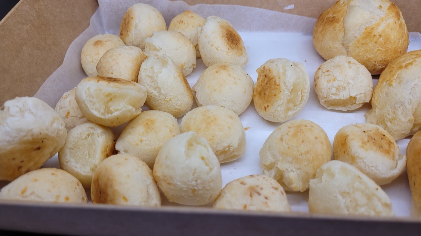 A box of freshly baked golden p&atilde;o de queijo, Brazilian cheese bread